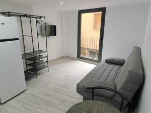 a living room with a couch and a television at Holidays Domus Papokkio in Igualada