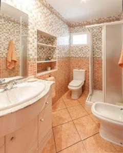 a bathroom with a toilet and a sink and a shower at Chalet Llamàntol in Oliva