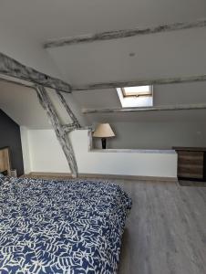 a bedroom with a bed with a blue bedspread at Le Bleuet in Spay