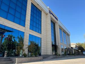 a building with glass windows on the side of it at AKS Hotel in Tashkent