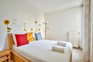 a bedroom with a large bed with colorful pillows at Appartement familial proche métro in Créteil