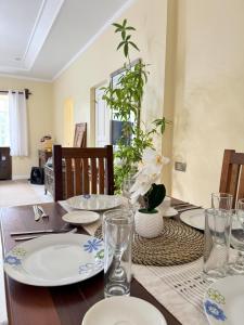 Una mesa de comedor con platos y vasos encima. en Cajigal Farmhouse - high speed converge internet and AC in 2 bedrooms, en Badoc 8 fotos más
