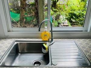 eine Küchenspüle mit einem Wasserhahn und einem Fenster in der Unterkunft บ้าน2ห้องนอน1ห้องน้ำเงียบสงบเดิน10นาทีถึงชายหาด in Ban Khlong Haeng + 16 Fotos