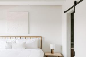 a bedroom with white walls and a bed with white pillows at Contemporary Cool Lifestyle Loft - Zuni Lofts in Denver