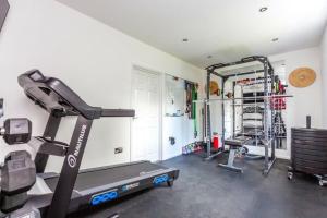 a room with a gym with a treadmill and weights at Very Large 5 Bed House Higham Ferrers family and contractors king beds Sky TV Pool Table Gym in Higham Ferrers