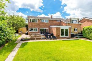 a brick house with a lawn in front of it at Very Large 5 Bed House Higham Ferrers family and contractors king beds Sky TV Pool Table Gym in Higham Ferrers