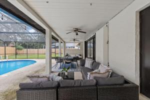 a patio with a couch and a table and a pool at Sunshine State Retreat Luxury Pool Home in Brandon