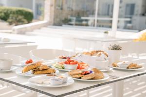 a table with several plates of food on it at Ambelas Mare Apartments in Ambelas