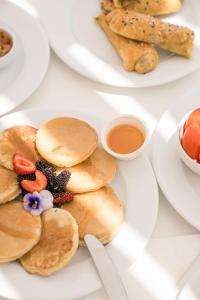 a plate of pancakes with fruit and a cup of coffee at Ambelas Mare Apartments in Ambelas