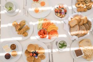 a white table with plates of food on it at Ambelas Mare Apartments in Ambelas