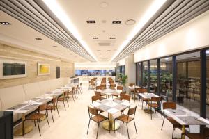 a restaurant with tables and chairs and windows at Pangyo KYND Tourist Hotel - Foreign Tourist Tax Return Hotel in Seongnam