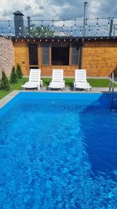 two white lounge chairs and a swimming pool at Zhamkochyan Guest House in Gukasavan