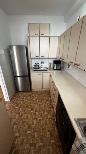 a kitchen with white cabinets and a stainless steel refrigerator at Retro City Center Gem by ARPA Hospitalities in Stellenbosch