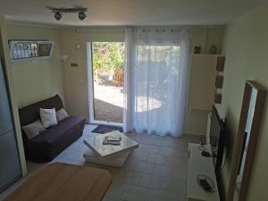 a living room with a couch and a sliding glass door at Chez Véro et Bernard in Entrevaux