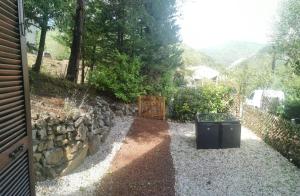 a garden with a stone wall and a gate at Chez Véro et Bernard in Entrevaux