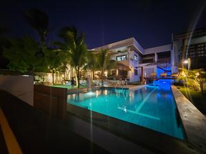 a swimming pool in front of a building at night at Upwind Villas Boutique - Praia de Maceió - Camocim - CE in Maceio