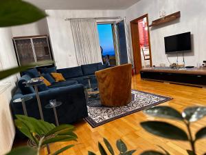 a living room with a blue couch and a television at Srce Cazina in Cazin