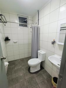 a white bathroom with a toilet and a sink at D'bey Melaka Homestay in Bukit Baru