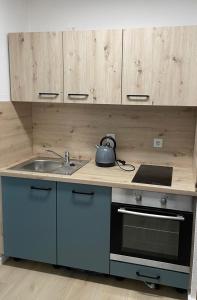 a kitchen with a sink and a stove and cabinets at Ferienwohnung Sieben, Zentral gelegene mit Tiefgaragenstellplatz in Bad Oeynhausen