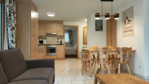 a kitchen and living room with a table and chairs at Studio au pied de la télécabine, SaastalCards Saas-Fee in Saas-Fee