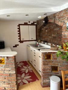 a kitchen with a brick wall and a sink at Studio Lipa in Maribor