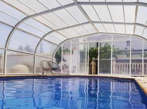 a large swimming pool with a retractable roof at Casa rural Camino de Morazara in Fines