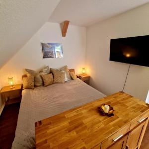 a bedroom with a large bed and a flat screen tv at Urlaubsdomizil Am Töpfer - Ferienwohnungen in Olbersdorf in Olbersdorf