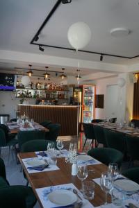 a restaurant with wooden tables and green chairs at Pensiunea Cascada in Borşa