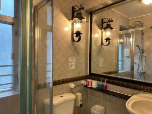 a bathroom with a toilet and a sink and a mirror at Bali Holiday Resort in Hong Kong