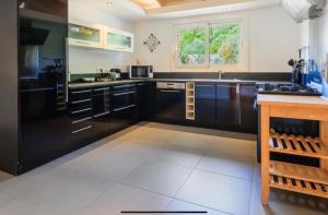 a large kitchen with black cabinets and a window at Casa A Sapa in Bonifacio