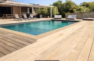 a swimming pool with blue water and chairs at Casa A Sapa in Bonifacio