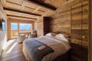 a bedroom with a bed in a room with wooden walls at Aïda Hôtel & Spa - "Adults Only" Relais & Châteaux in Crans-Montana +68 photos