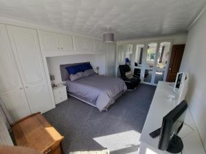 a bedroom with a bed and a desk with a computer at Spacious & Upmarket 2 Bedroom Detached Bungalow in Boston in Boston