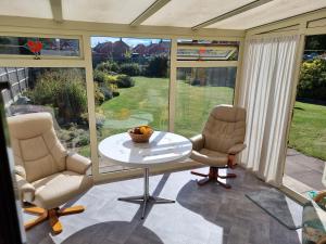 a screened in porch with two chairs and a table at Spacious & Upmarket 2 Bedroom Detached Bungalow in Boston in Boston