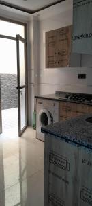 a kitchen with a washing machine and a counter with boxes at إقامة حي المطار شارع 80 in Nador