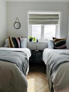 two beds in a room with a window at Hidden Gem Whitstable in Whitstable +11 photos