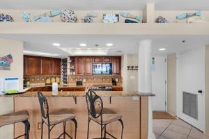a kitchen with a counter with stools around it at East Pass 308 in Destin