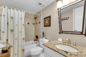 a bathroom with a sink and a toilet and a tub at East Pass 308 in Destin +49 photos