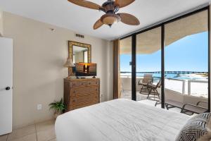 a bedroom with a bed and a television and a balcony at East Pass 308 in Destin