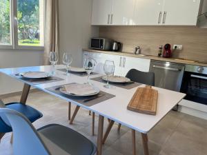 a kitchen with a table with wine glasses on it at Maison indépendante 2 Chambres avec terrasse et jardin in Saint-Aunès