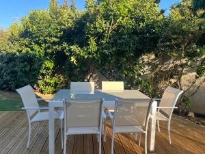 a blue table and chairs on a wooden deck at Maison indépendante 2 Chambres avec terrasse et jardin in Saint-Aunès