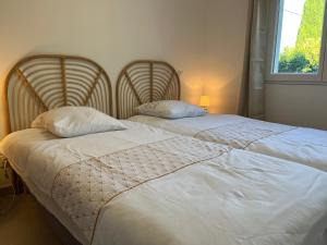 two beds sitting next to each other in a bedroom at Maison indépendante 2 Chambres avec terrasse et jardin in Saint-Aunès