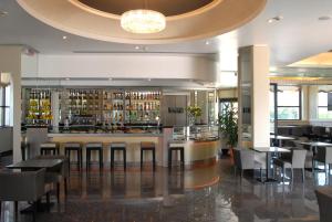 a restaurant with a bar with tables and chairs at Grand Hotel Duca Di Mantova in Sesto San Giovanni
