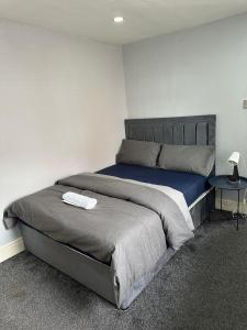 マンチェスターにあるBudget Room with Private Bathroomのベッドルーム1室(大型ベッド1台、サイドテーブル付)