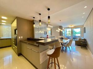 a kitchen and dining room with a table and chairs at Apartamento de Última Geração em Atlântida in Xangri-lá