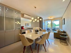 a dining room and kitchen with a table and chairs at Apartamento de Última Geração em Atlântida in Xangri-lá +7 photos