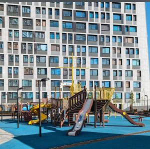 einen Spielplatz vor einem großen Gebäude in der Unterkunft NEW APART Lesi Ukrainky Blvd and Olimpiyska and KRESHCHATYK and Manhattan City with parking in Kiew
