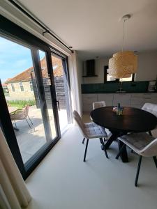 a kitchen and dining room with a table and chairs at Muziekskuur in Hollum +15 photos