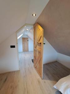 Habitación en el ático con una puerta que conduce a un dormitorio en Muziekskuur, en Hollum