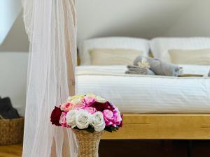 a bouquet of flowers in a basket next to a bed at STUDIO KRÁLOVICE Apartment in Prague
